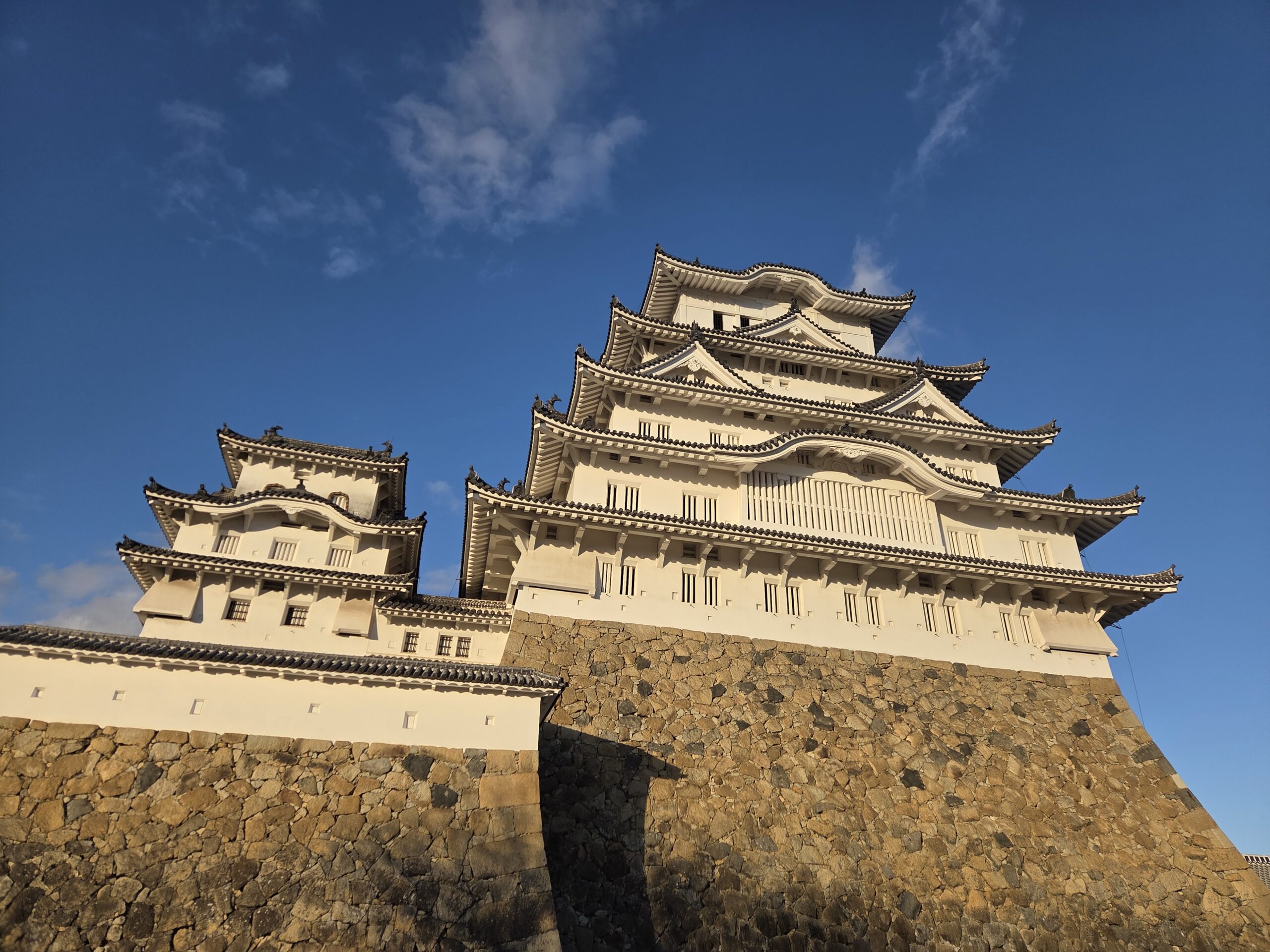 Himeji Castle, Japan's magnificent white castle and a UNESCO World Heritage Site, viewed under a clear sky.