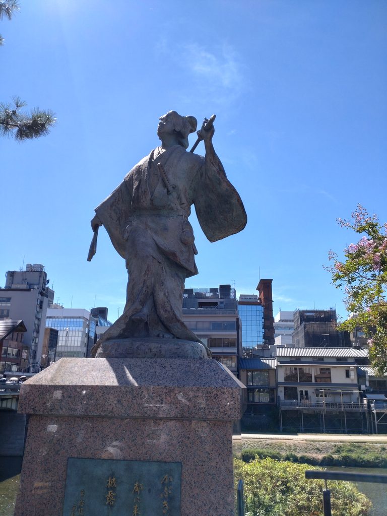 Statue of Izumo no Okuni in Gion, Kyoto, under a clear blue sky