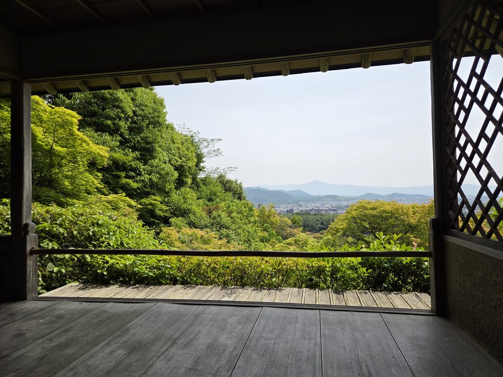 View of Kyoto and distant mountains framed by greenery from Okochi Sanso Garden