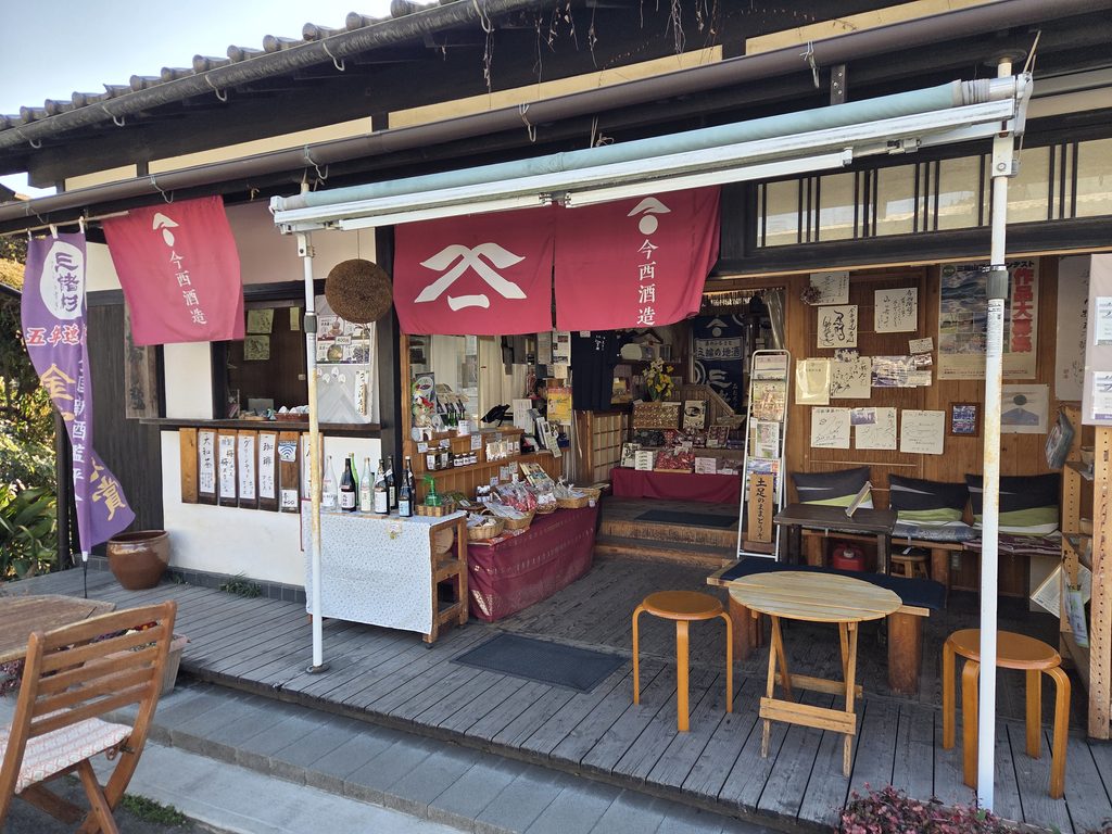 Traditional storefront of Imanishi Sake Brewery with red noren curtains along the approach to Omiwa Shrine in Sakurai, Nara