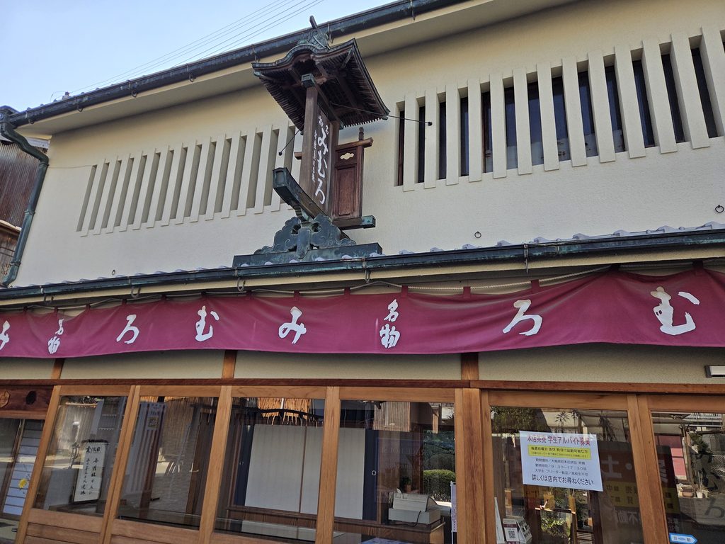 Traditional wooden hanging sign and noren curtain of the Mimuro confectionery shop near Omiwa Shrine in Sakurai, Nara
